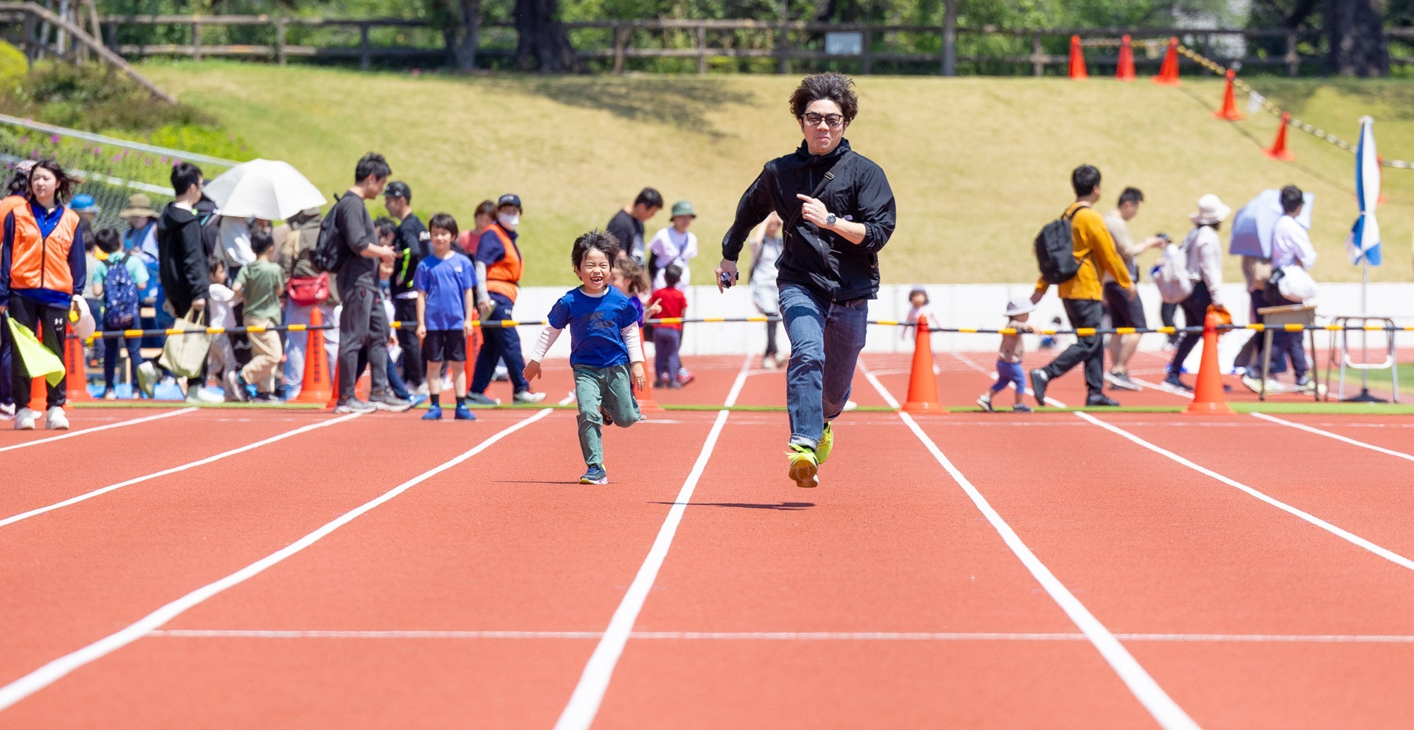 写真：ファミリースポーツフェアで親子が50メートル走を走る様子