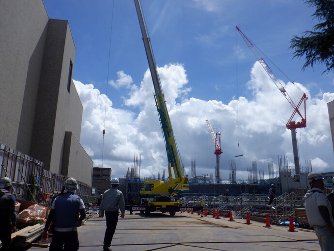 写真:クレーン車等で部材を運んでいます。