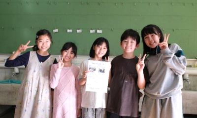 画像：作成したプレスリリース文と記念撮影している子どもの様子