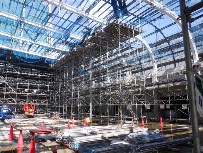 写真：屋根の部材をクレーンで移動させています。