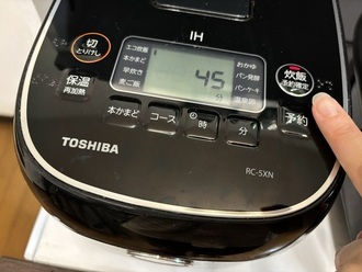 写真：炊飯器のボタンを押す様子