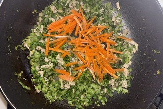 写真：葉と茎とにんじんを炒める様子